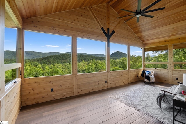 unfurnished sunroom with lofted ceiling, a mountain view, a wealth of natural light, and wooden ceiling