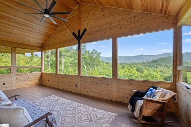 unfurnished sunroom with lofted ceiling, a mountain view, ceiling fan, and wooden ceiling