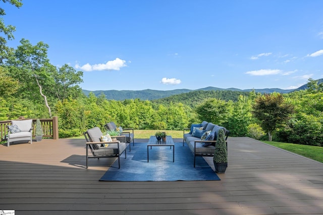 wooden terrace with an outdoor living space and a mountain view