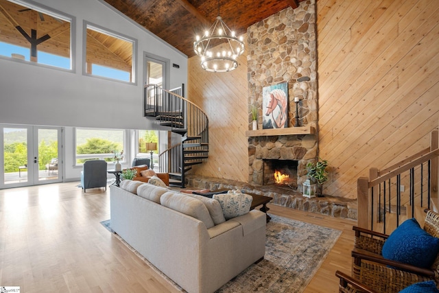 living room with high vaulted ceiling, a wealth of natural light, and a stone fireplace