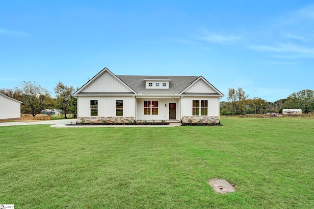 modern inspired farmhouse featuring stone siding, a shingled roof, and a front yard