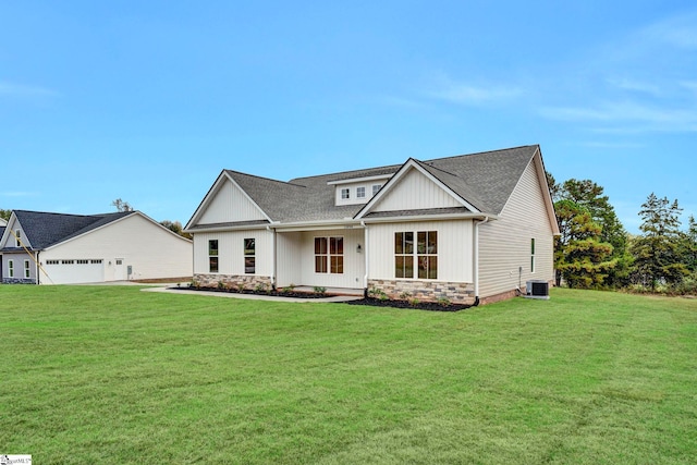 modern inspired farmhouse featuring central air condition unit, board and batten siding, a garage, stone siding, and a front lawn