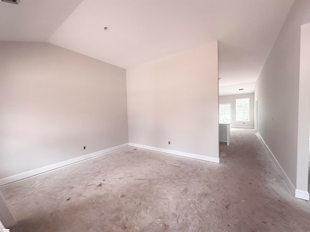 empty room featuring concrete flooring and vaulted ceiling