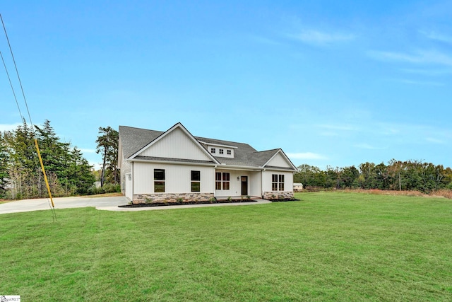 modern farmhouse featuring stone siding and a front lawn