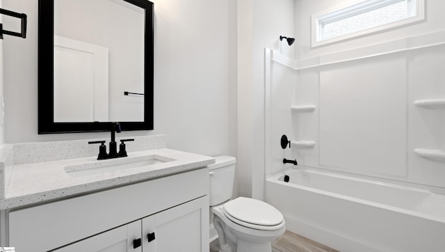 bathroom featuring toilet, vanity, and shower / tub combination