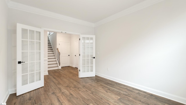 empty room featuring french doors, dark wood-style flooring, stairway, ornamental molding, and baseboards