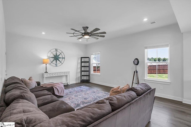 living room featuring ceiling fan and dark wood-type flooring