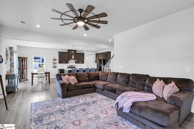 living room with ceiling fan and light wood-type flooring