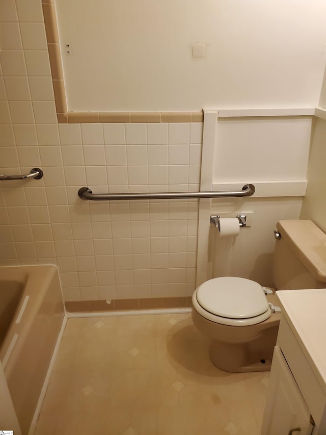 bathroom featuring tile patterned flooring, tile walls, toilet, and vanity