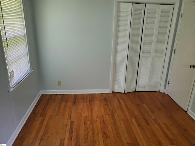 unfurnished bedroom with hardwood / wood-style floors and a closet