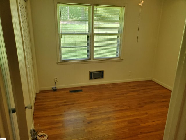 spare room featuring a wealth of natural light and hardwood / wood-style flooring