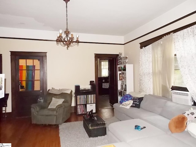 living room featuring wood-type flooring, an inviting chandelier, and cooling unit