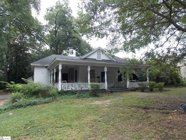 view of front of house with covered porch and a front lawn