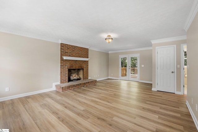 unfurnished living room with a brick fireplace, light hardwood / wood-style flooring, french doors, crown molding, and brick wall