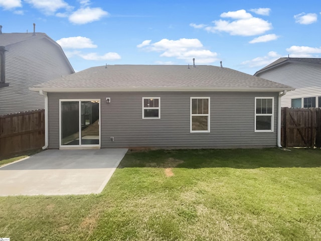 back of house with a yard, a shingled roof, a patio area, and fence