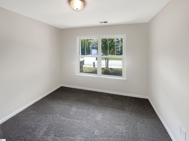 empty room with carpet floors, visible vents, and baseboards