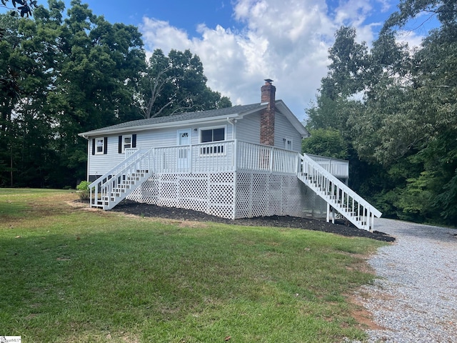 view of front of house featuring a wooden deck and a front lawn