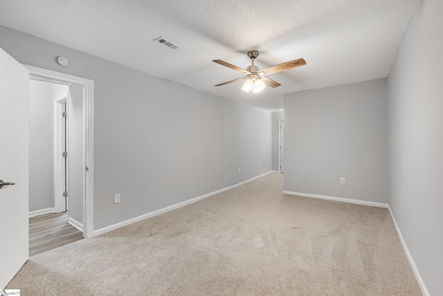 carpeted empty room with a textured ceiling and ceiling fan