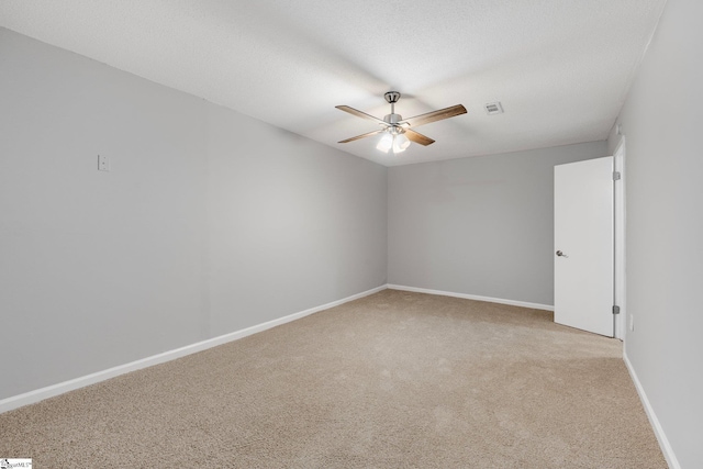 carpeted empty room with ceiling fan and a textured ceiling