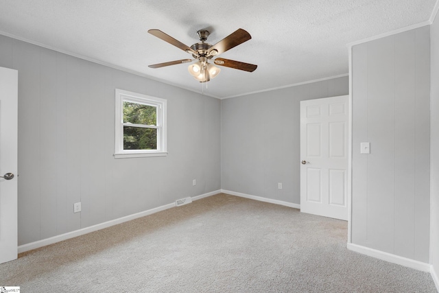 spare room featuring ceiling fan, crown molding, carpet, and a textured ceiling