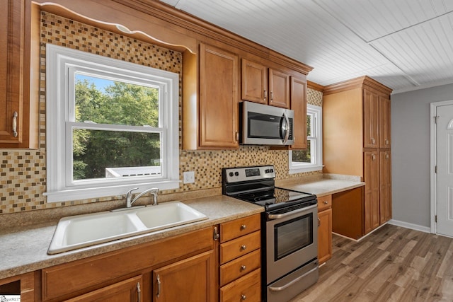 kitchen featuring sink, appliances with stainless steel finishes, hardwood / wood-style flooring, and decorative backsplash