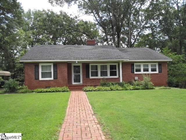 ranch-style house with a shingled roof, a front yard, and brick siding