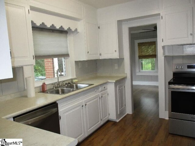 kitchen featuring sink, electric range, dishwashing machine, white cabinets, and dark wood-type flooring