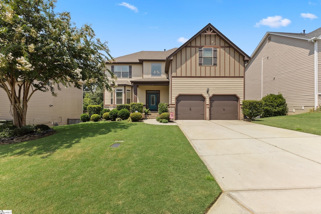 craftsman-style home with concrete driveway, a front lawn, board and batten siding, and an attached garage