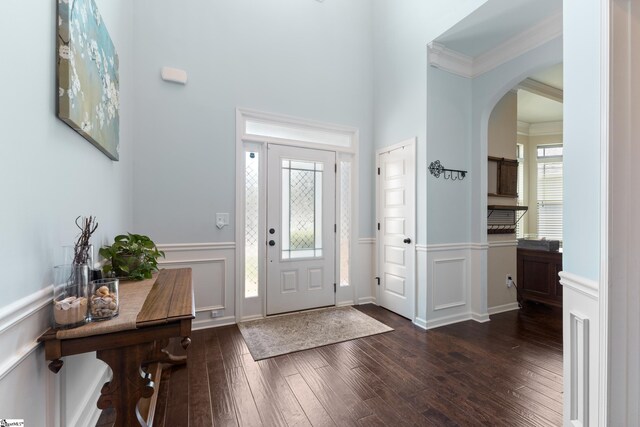 foyer with crown molding and dark wood-type flooring