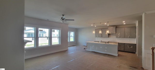 333 Alyssa Landing Dr Unit 72, Fountain Inn, SC 29644 - kitchen featuring backsplash, an island with sink, ceiling fan, baseboards, and gray cabinetry