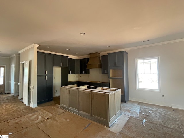 kitchen with ornamental molding, a kitchen island, and custom range hood