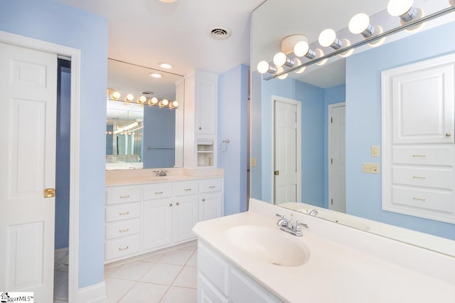 bathroom with visible vents, two vanities, a sink, and tile patterned floors