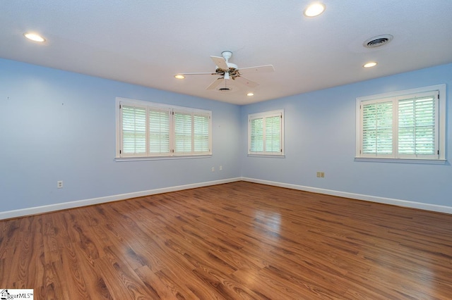 spare room with baseboards, visible vents, wood finished floors, and recessed lighting