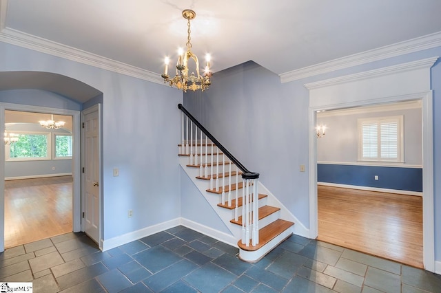 staircase with an inviting chandelier, arched walkways, wood finished floors, and ornamental molding