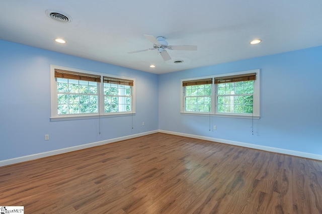 spare room with ceiling fan, recessed lighting, wood finished floors, visible vents, and baseboards