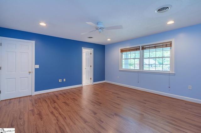 empty room with visible vents, baseboards, and wood finished floors