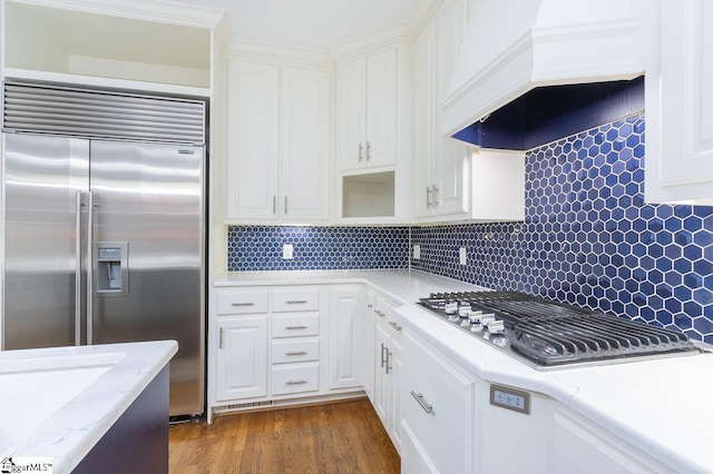 kitchen with stainless steel appliances, dark wood-style flooring, premium range hood, and white cabinets