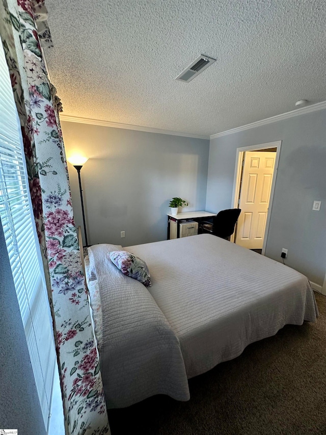 bedroom with crown molding, a textured ceiling, and carpet