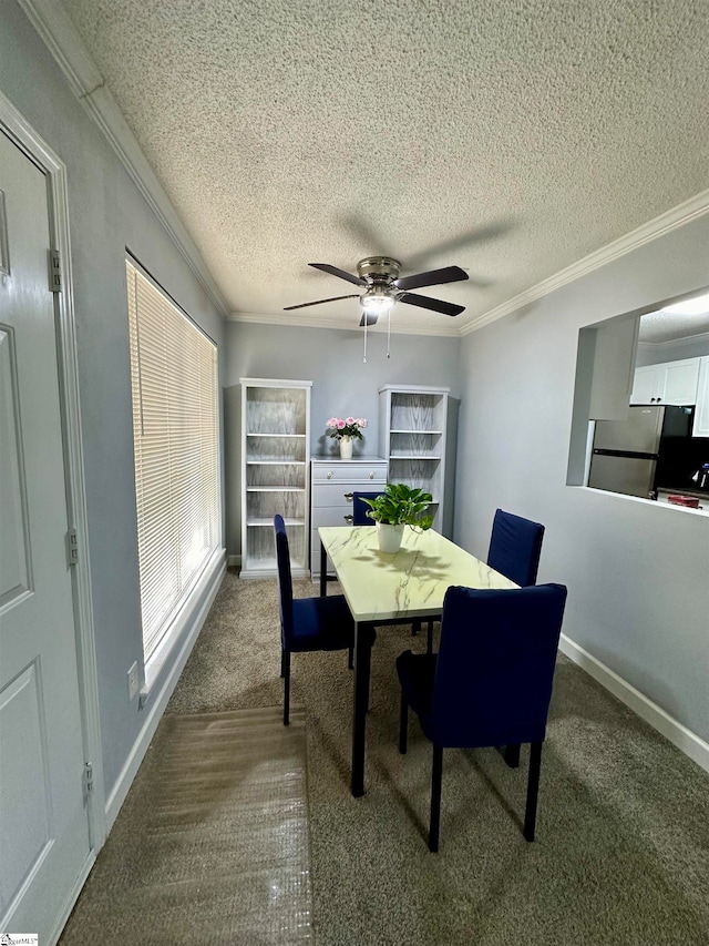 carpeted dining space featuring a textured ceiling, ceiling fan, and ornamental molding