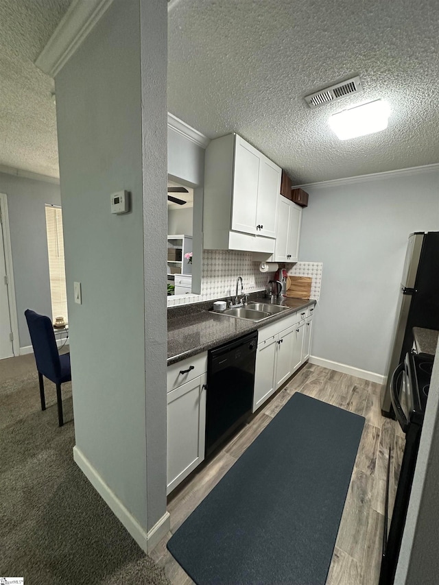 kitchen featuring black dishwasher, light hardwood / wood-style flooring, sink, and white cabinets