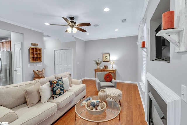 living room with ceiling fan, ornamental molding, and wood-type flooring