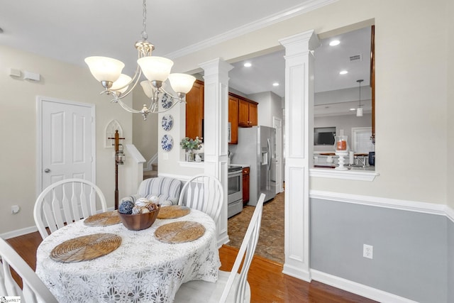 dining area featuring a notable chandelier, dark wood-type flooring, and ornate columns