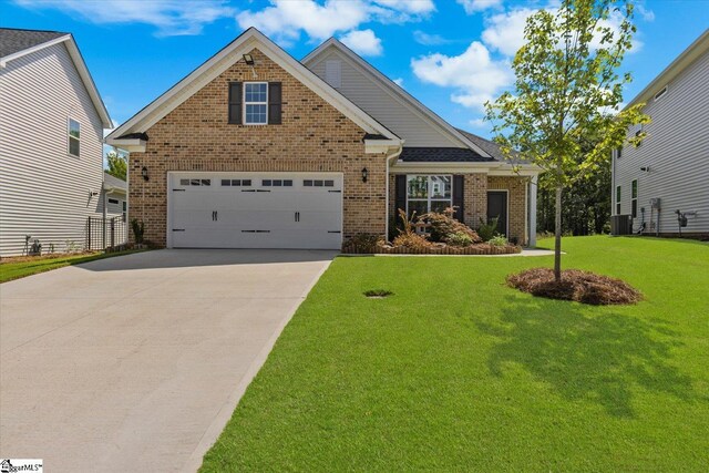 craftsman house featuring a garage, central AC unit, and a front yard