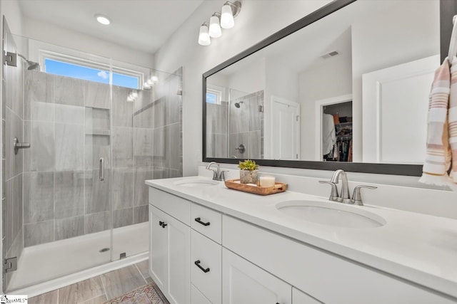 bathroom with a shower with door, vanity, and hardwood / wood-style flooring