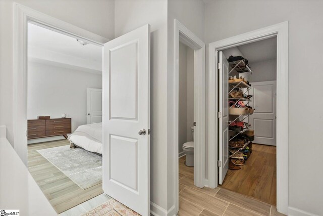 clothes washing area with washer and clothes dryer and light wood-type flooring