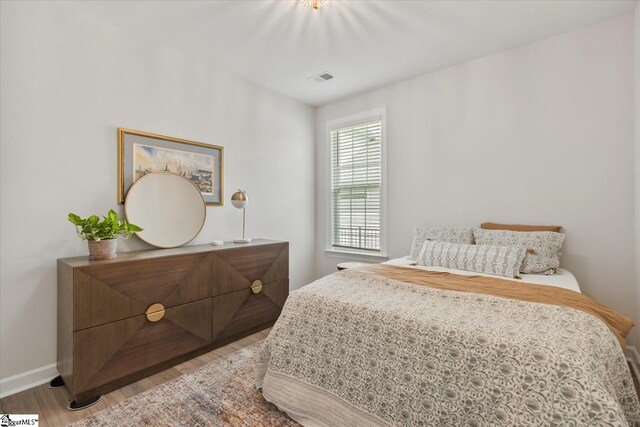 bedroom with wood-type flooring and a closet