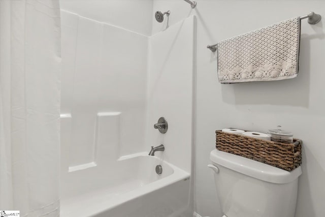 bathroom featuring shower / tub combo and toilet