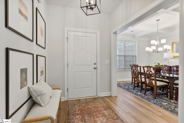 entryway featuring wood-type flooring, an inviting chandelier, beam ceiling, and coffered ceiling