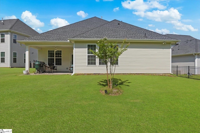 rear view of property featuring a lawn and a patio