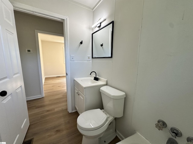 bathroom featuring visible vents, toilet, vanity, wood finished floors, and baseboards